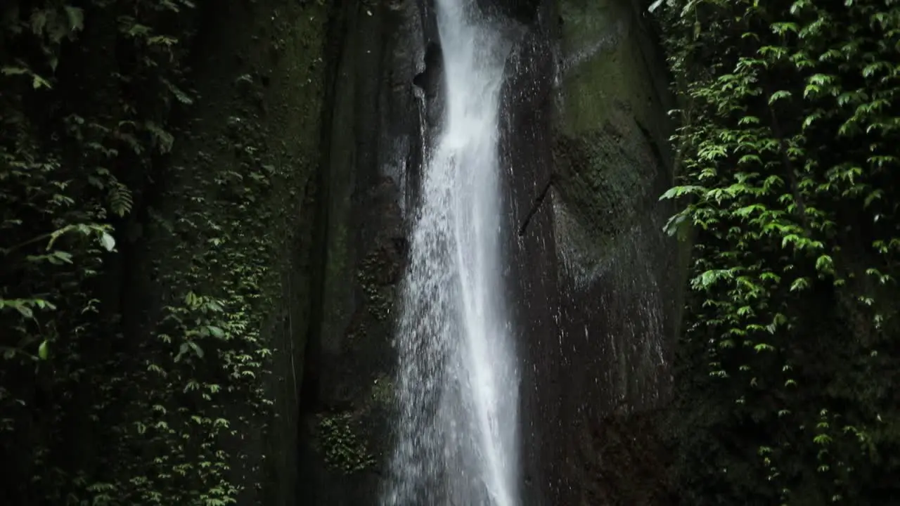 Slow motion panning up shot in front of a gushing Leke Leke Waterfall in Bali Indonesia following a rain storm