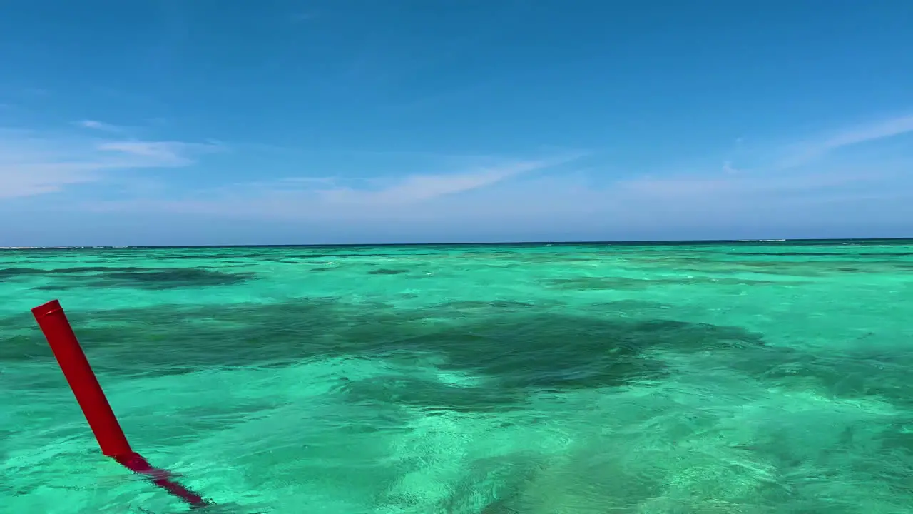 Blue sky meets Turquoise waters as a red buoy passes by near Punta Cana Dominican