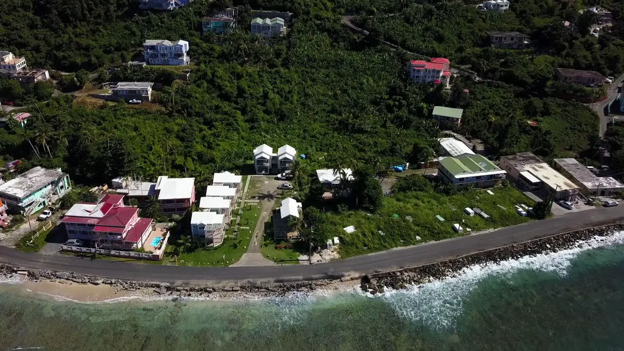 Aerial approach over water to local homes on a beach BVI island Tortola