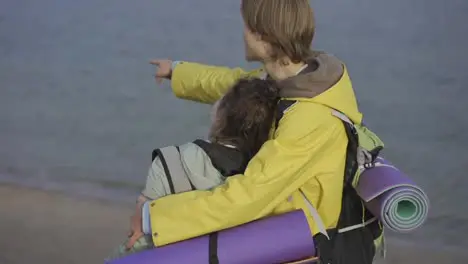 Couple exploring nature Hiker pointing finger on seaside view