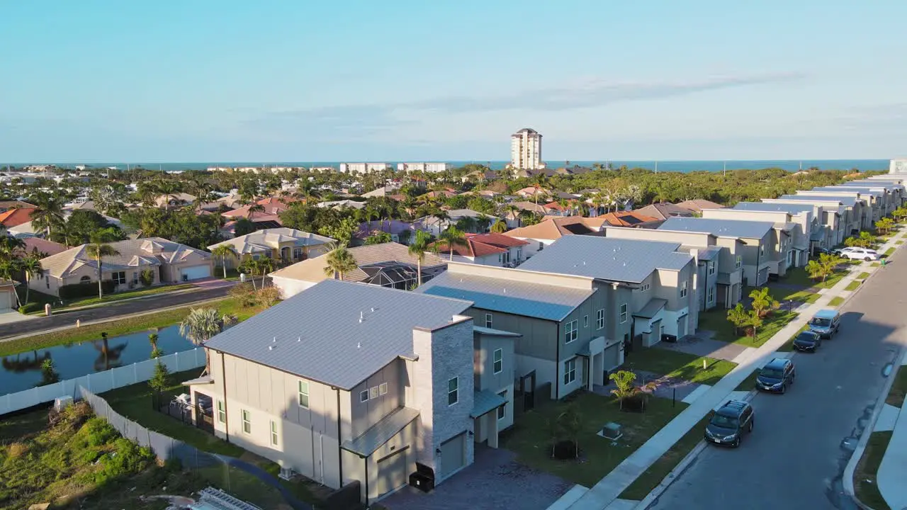 A 4k drone shot picturing a pool with palm trees near it and a hotel in the background