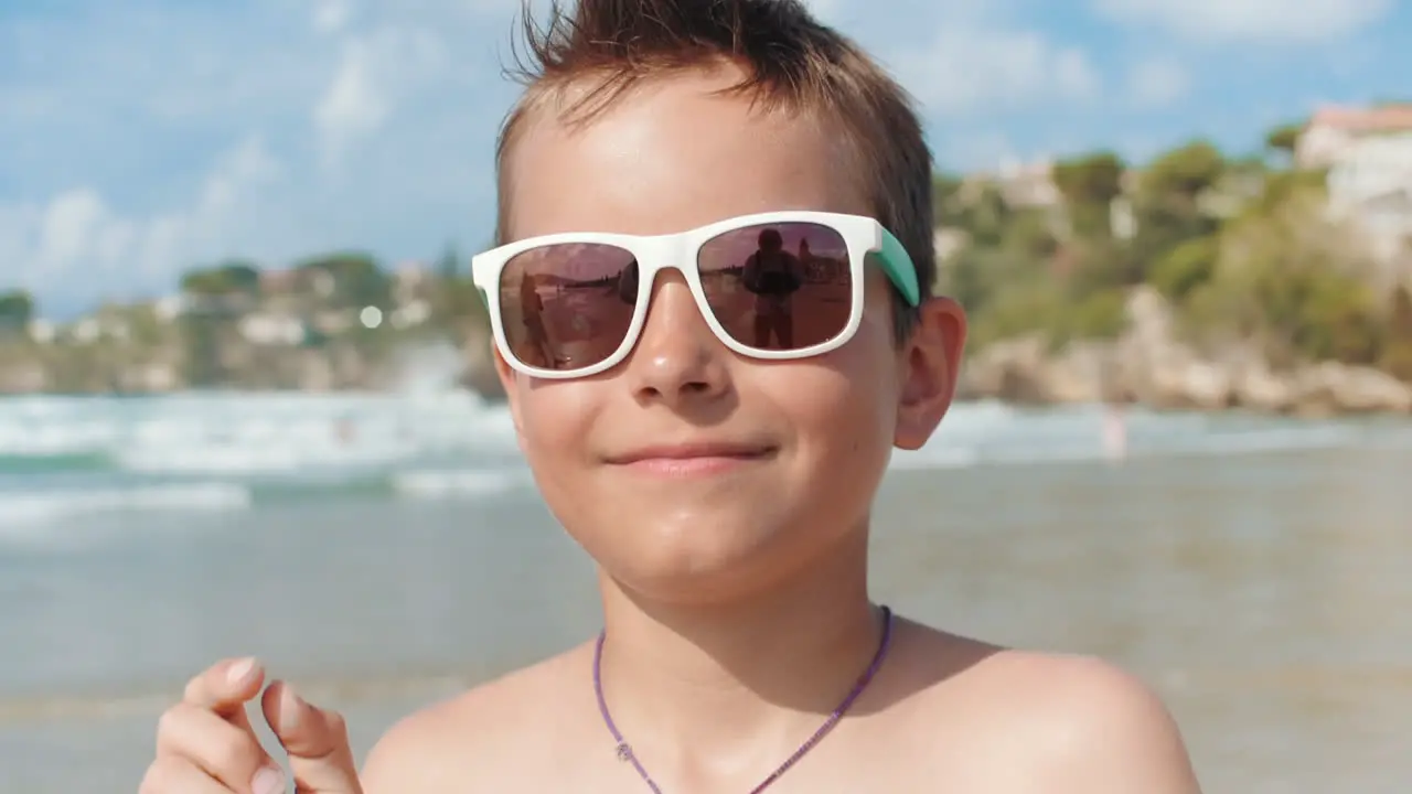 Cheerful boy relaxing at coastline Smiling guy enjoying summer at seaside