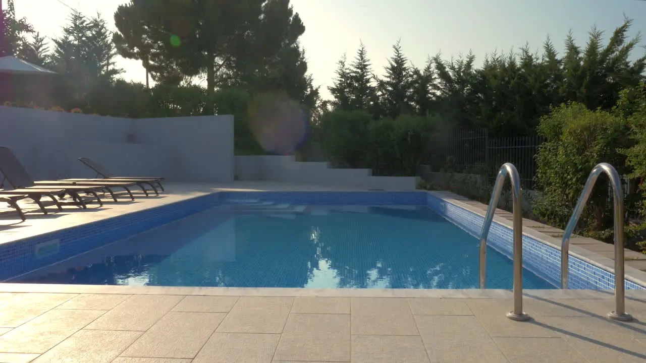 Outdoor swimming pool and empty deck-chairs