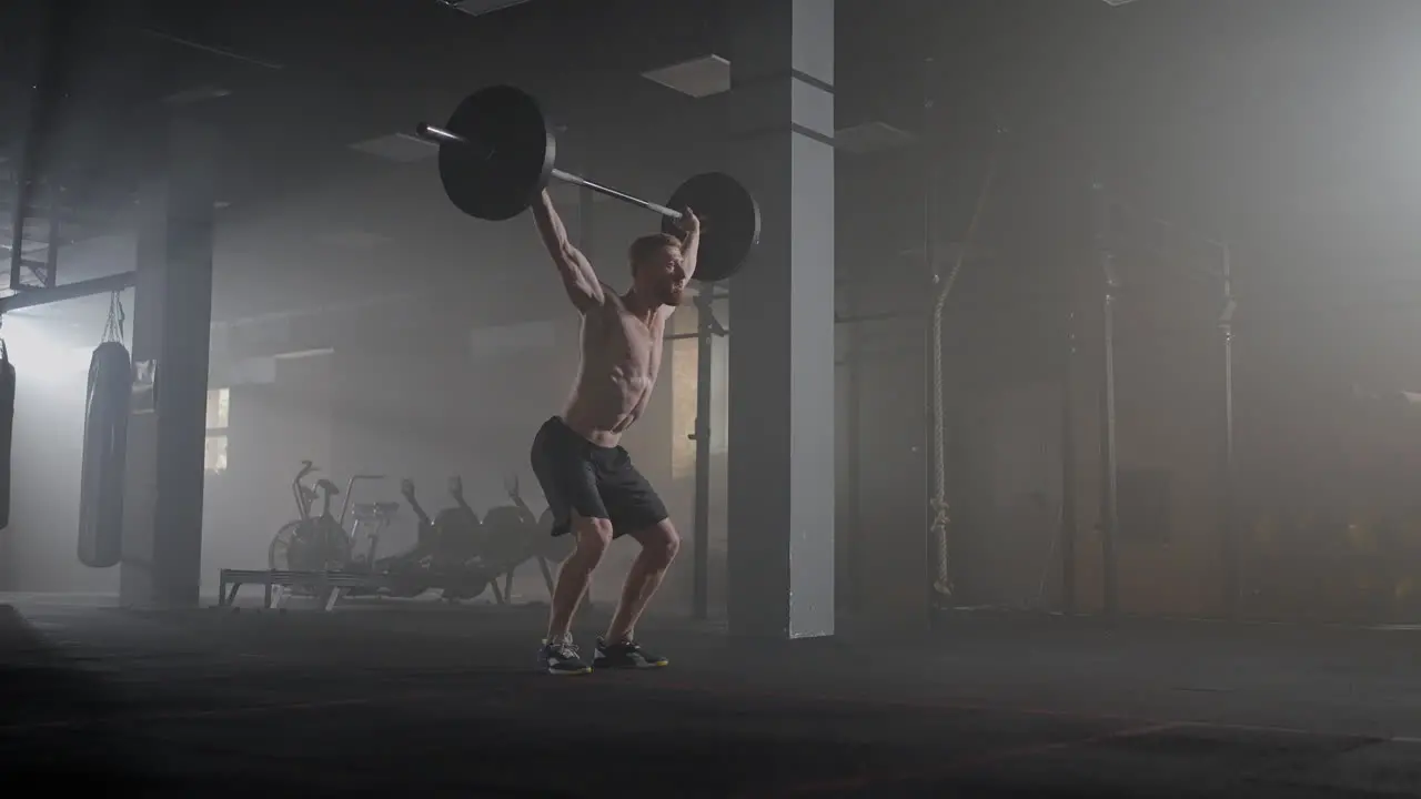 Handsome Muscular Man Does Deadlift and Curls with a Heavy Barbell Athletic Shirtless Man Training Doing Power Strength and Endurance Exercises with Barbell Workout in the Hardcore Gym