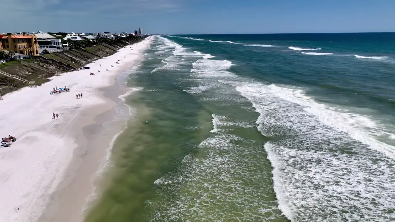 Seaside Flordia aerial push into waves along surf