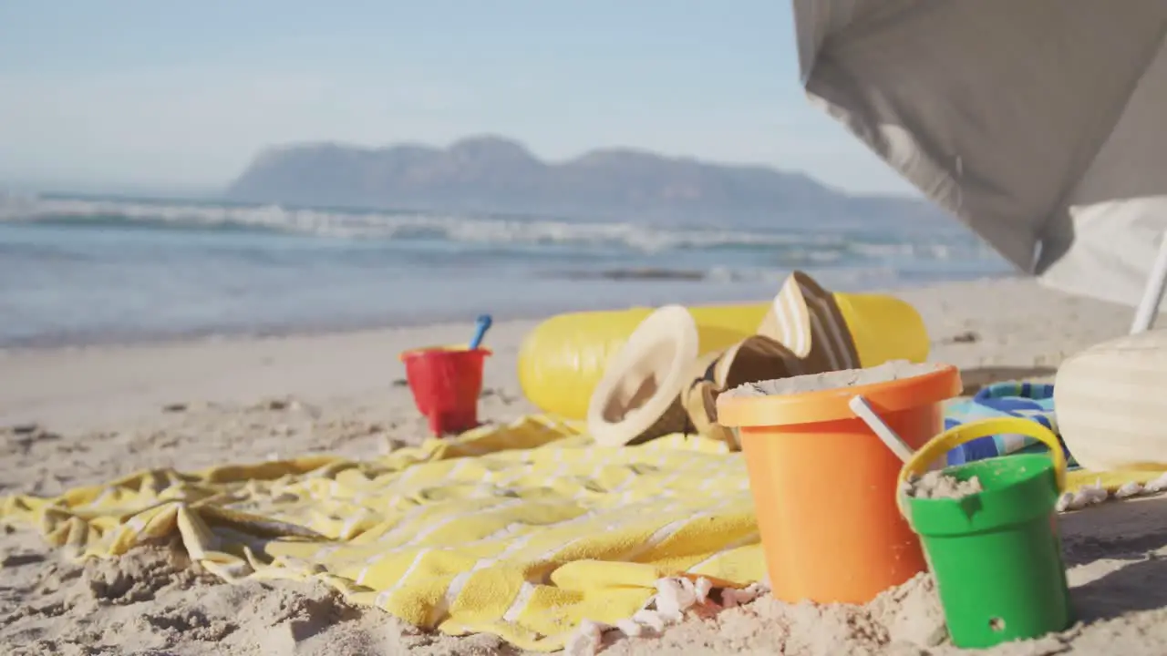 View of umbrella san buckets hats and blanket on the beach