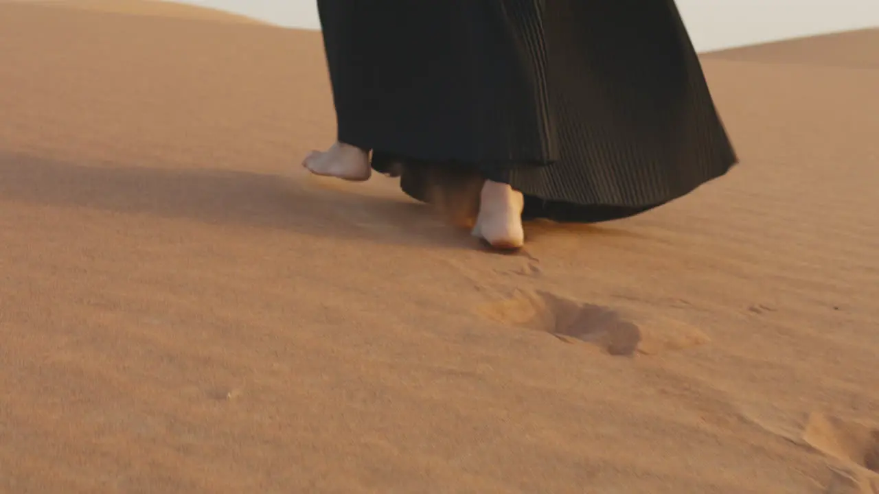 Close Up Of An Unrecognizable Muslim Woman Walking Barefoot In The Desert