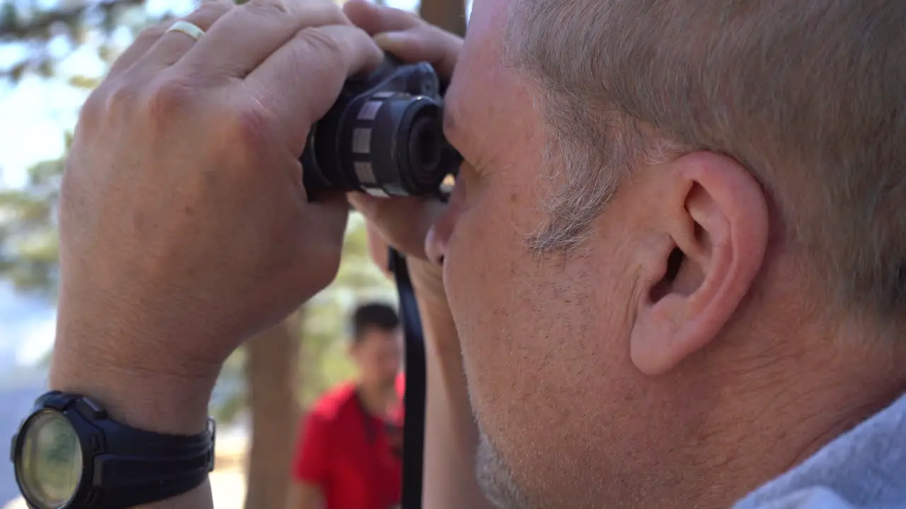 4K Tourist Man Looking at Half Dome Through Binoculars on Glacier Point in Yosemite National Park California