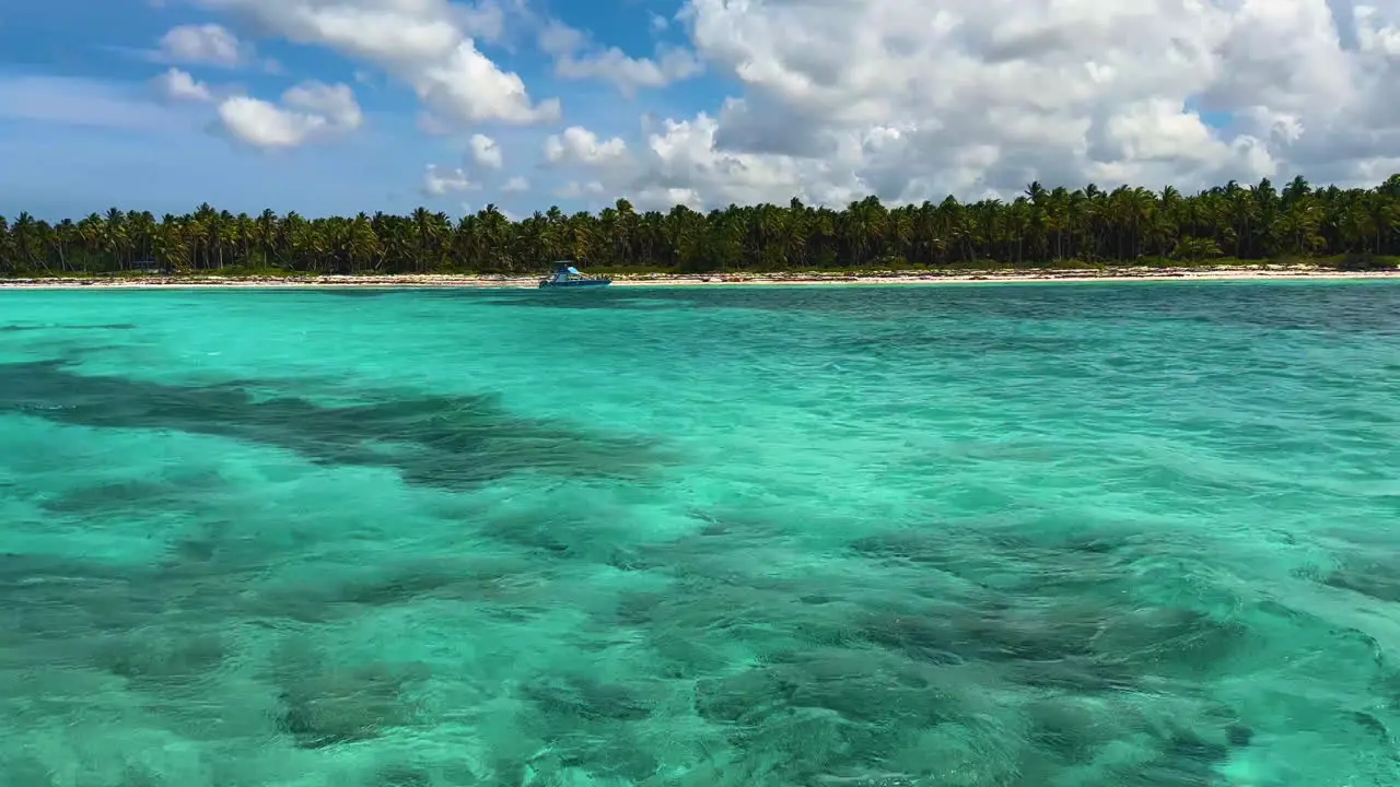 the beautiful turquoise waters of the Caribbean with a small watercraft passing along the islands shore