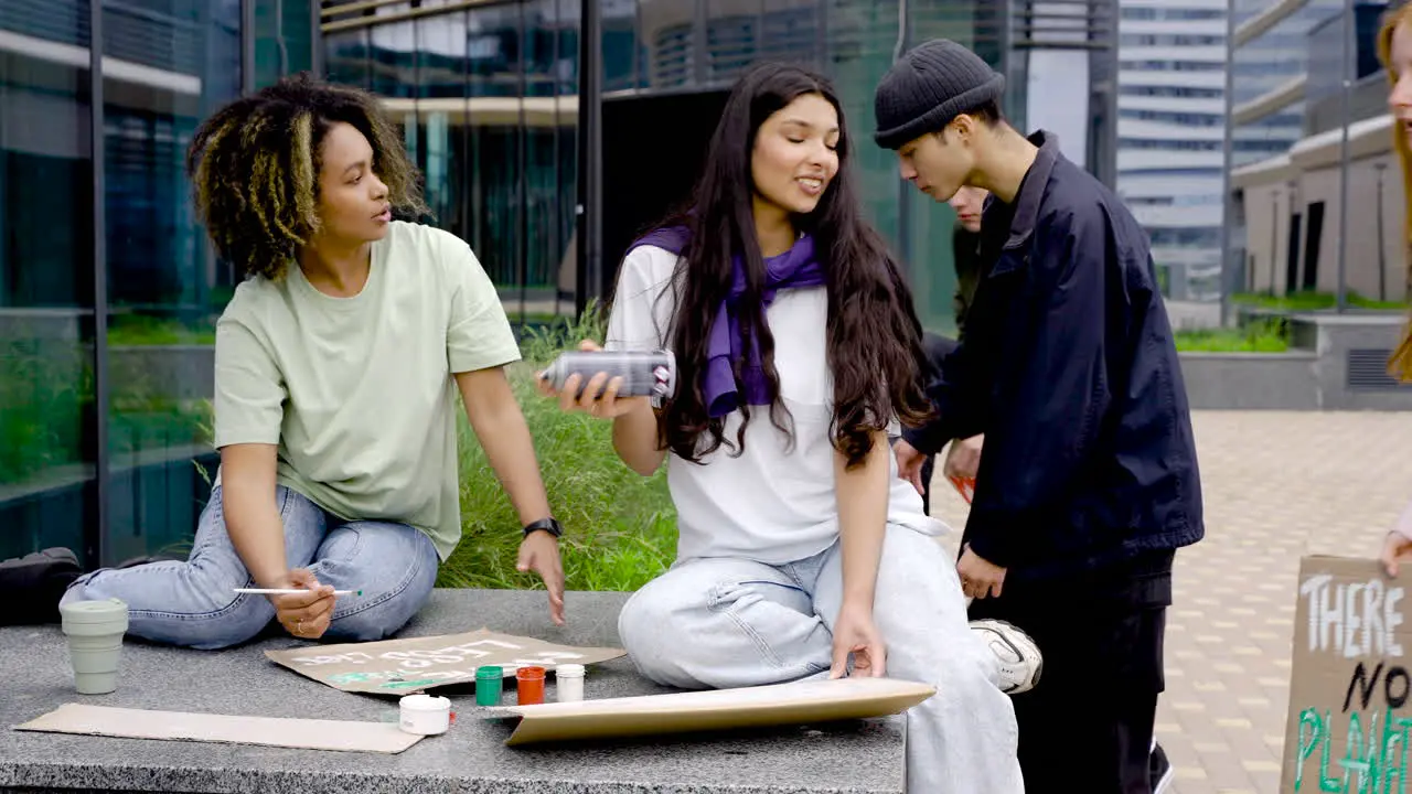 Two Young Women Finishing Their Board While Their Friends Go To Help Them