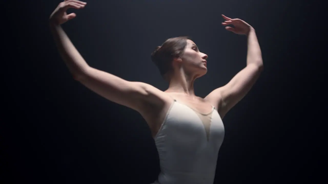 Sensual dancer performing with raised hands indoors Ballerina dancing in class