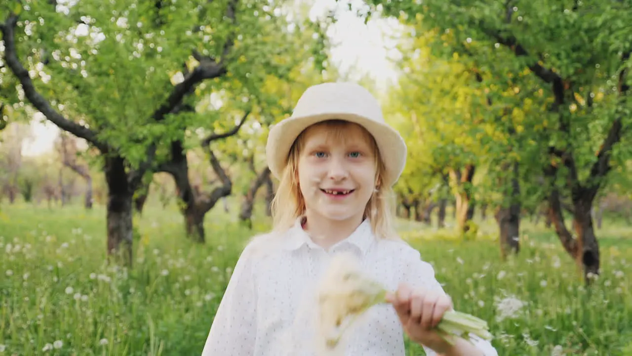 A Happy Child Is Running Happily Through The Garden Bouncing And Waving A Bouquet Of Dandelions Care