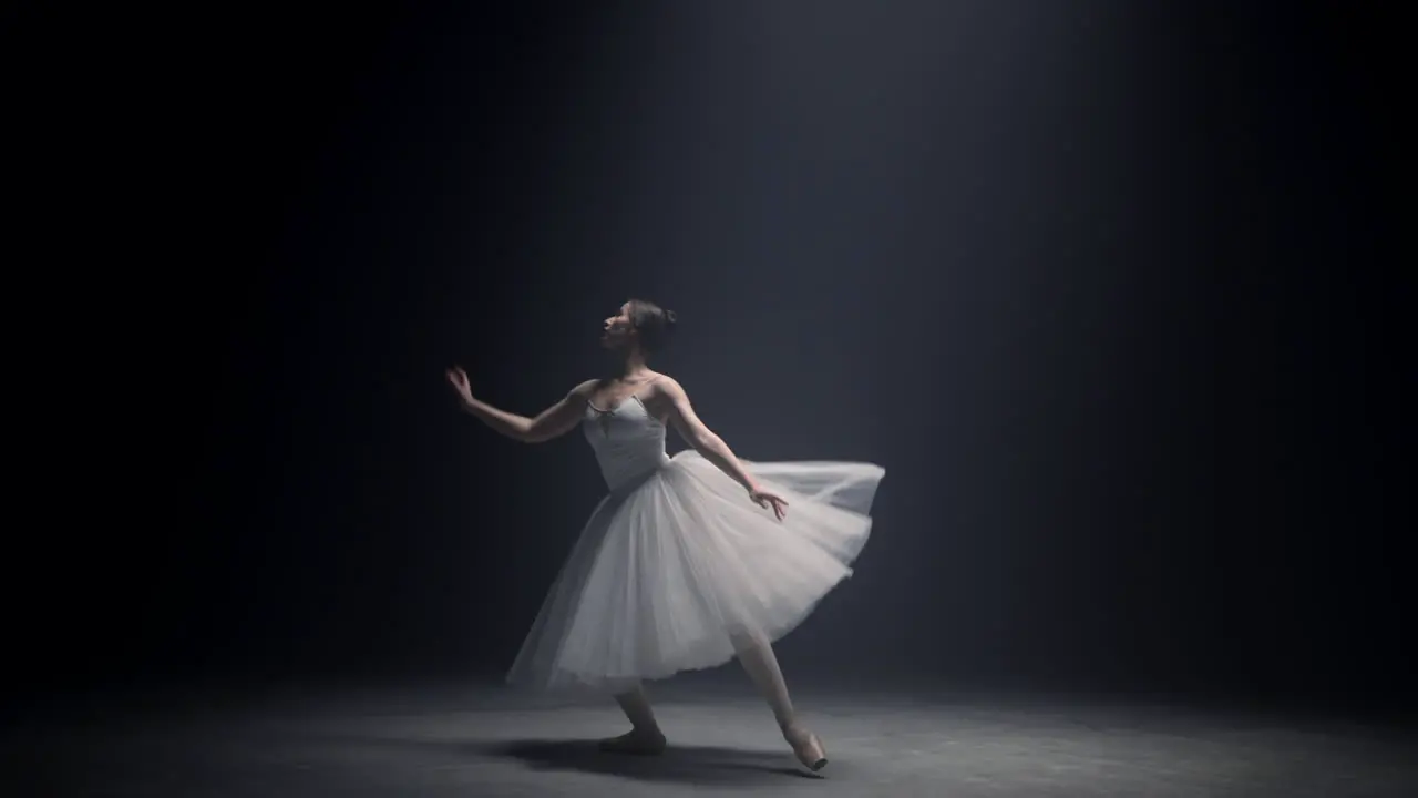 Sensual ballerina dancing on stage Graceful ballet dancer performing indoors