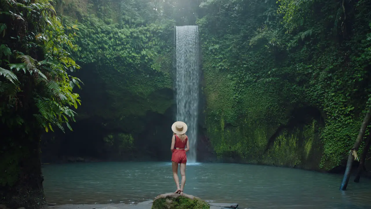 travel woman looking at waterfall in rainforest jungle exploring alone enjoying exotic vacation 4k