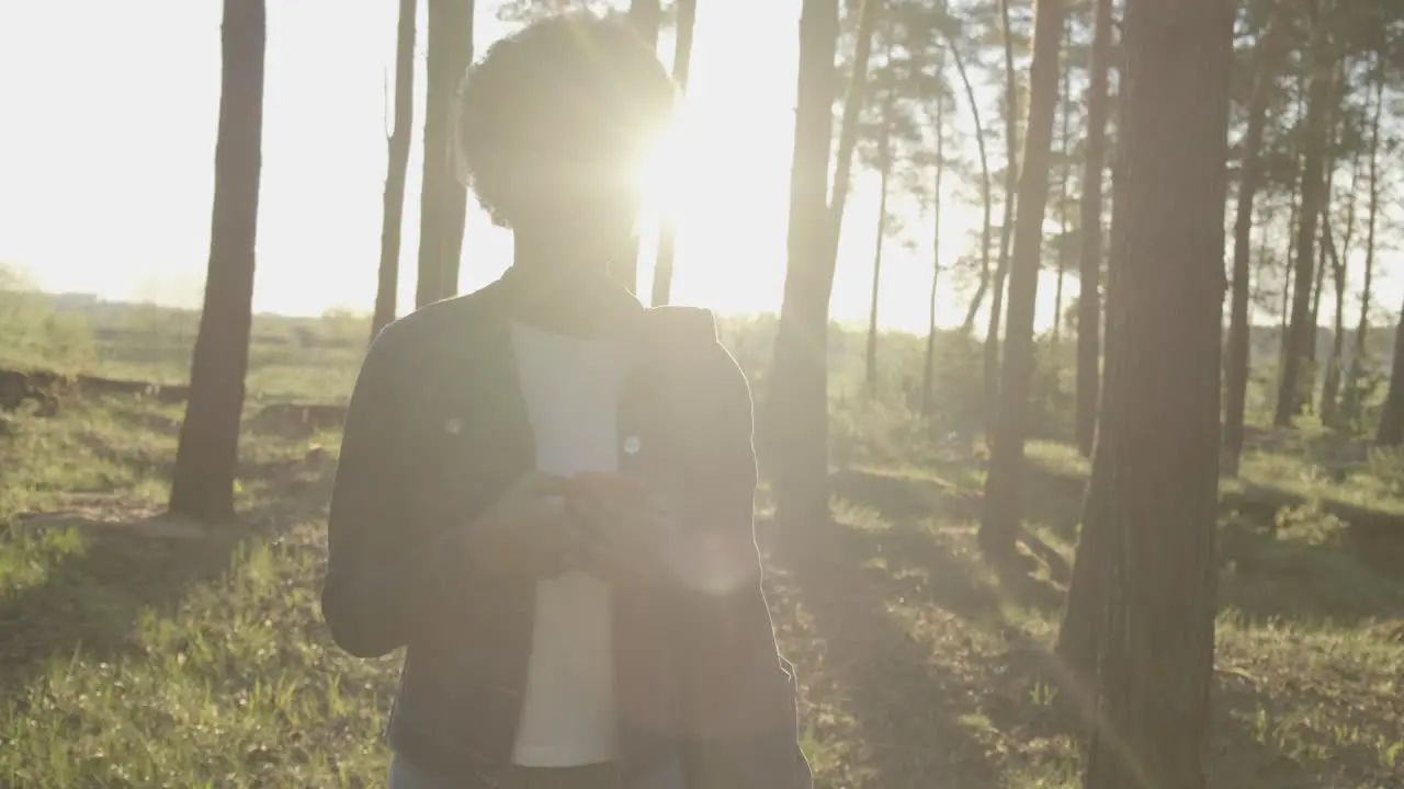 A Pretty Girl Taking Pictures Of The Forest At Sunset With Her Cellphone