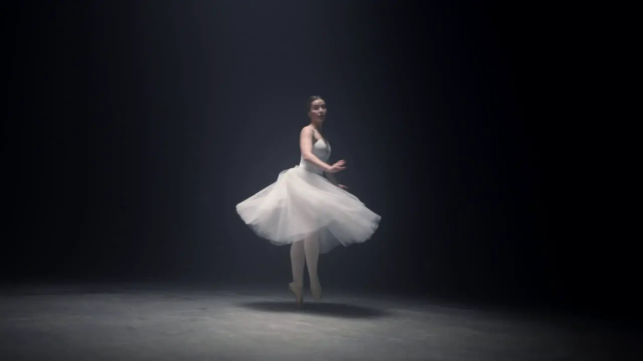 Pretty ballerina spinning around on tiptoe Ballet dancer dancing on stage