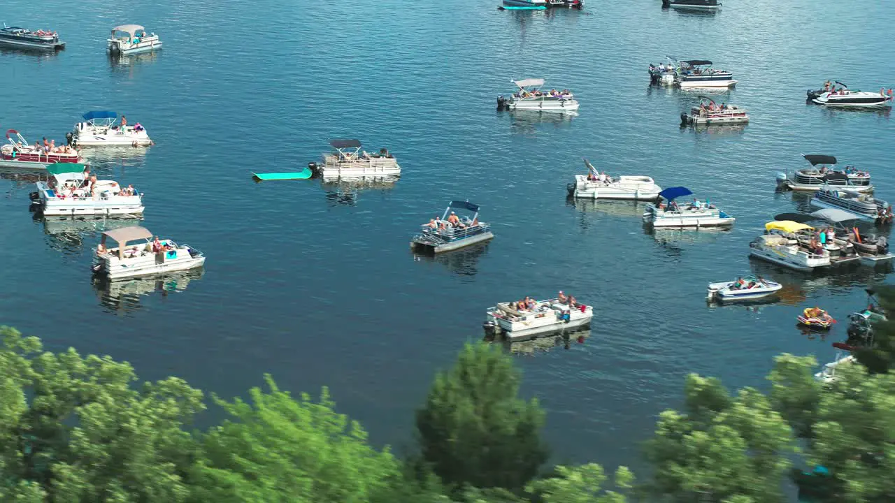 Aerial spring break party boats crowded with people on lake during summer holiday