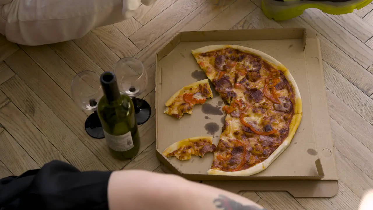 Top View Of Pizza Wine Bottle And Glasses On A Wooden Floor