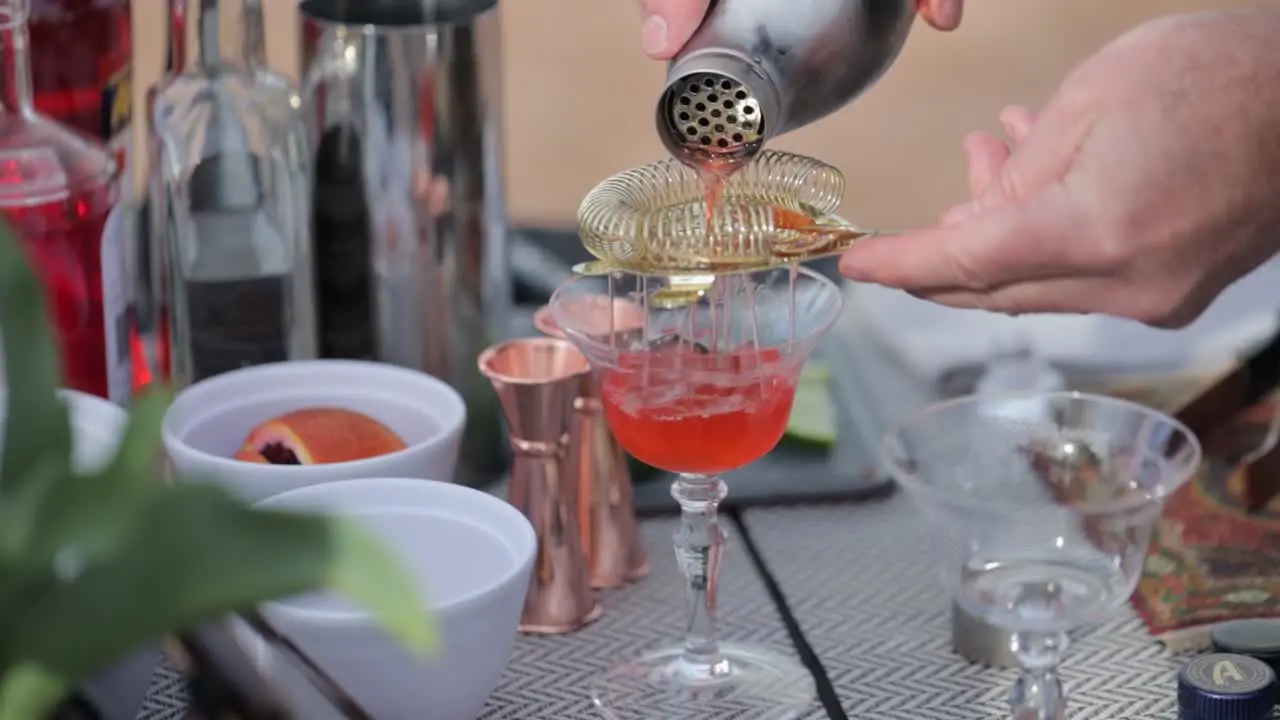 Outdoor bar with a cocktail being poured into a crystal glass on a spring themed table