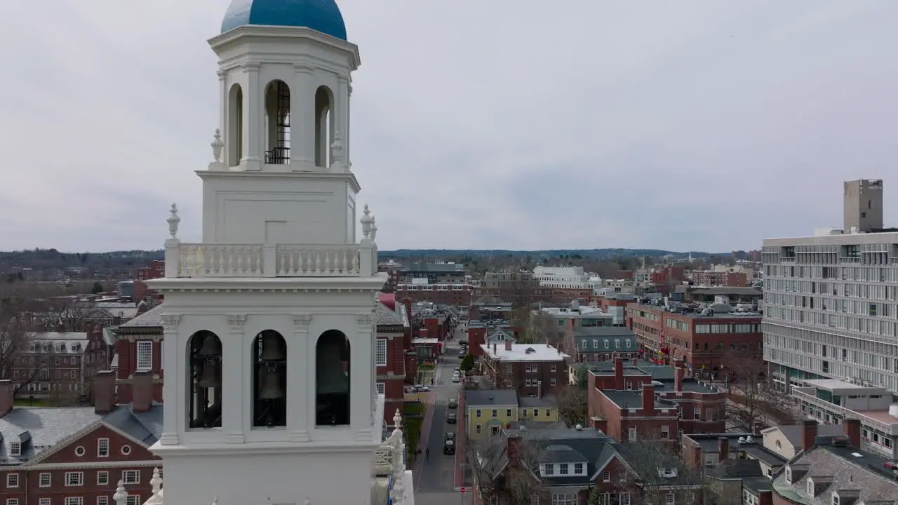 Forwards fly above old buildings on Harvard University site Tight flight around white tower with bells Boston USA