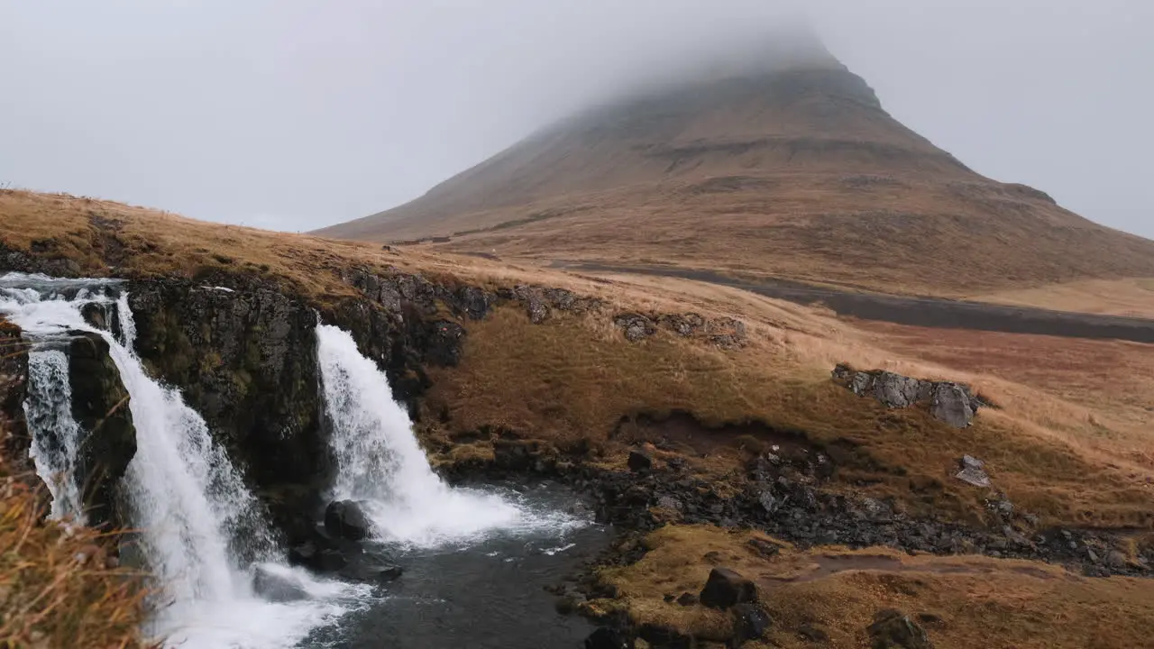 Slow tracking shot of Kirkjufellsfoss Waterfall and Kirkjufell Iceland in cold mist