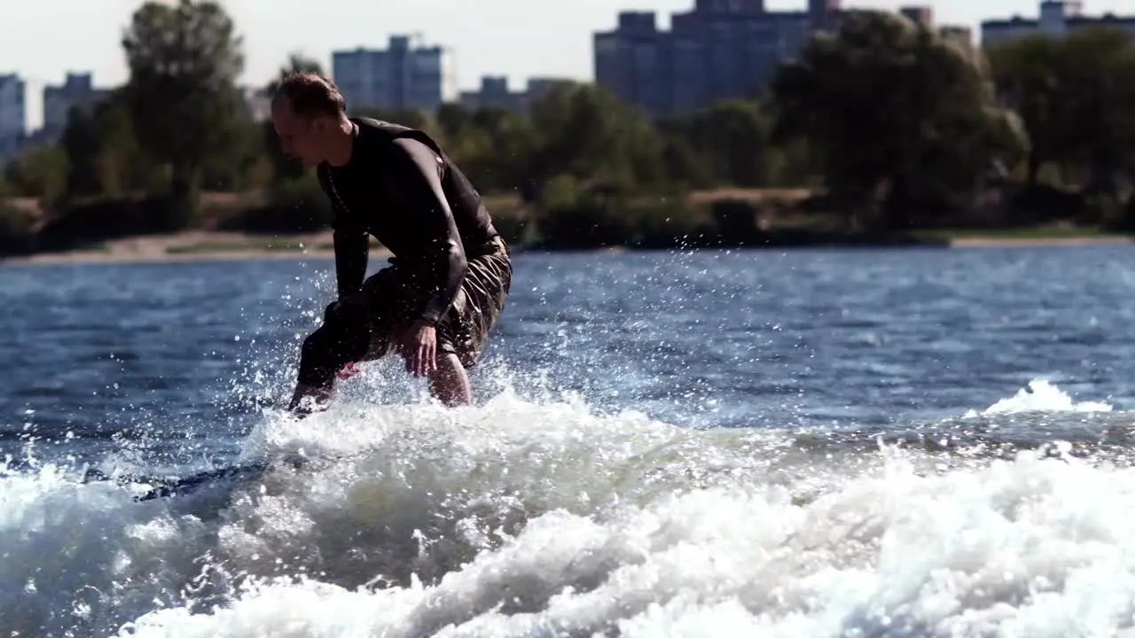 Wakeboarder surfing on board on waves Extreme aquatic sport