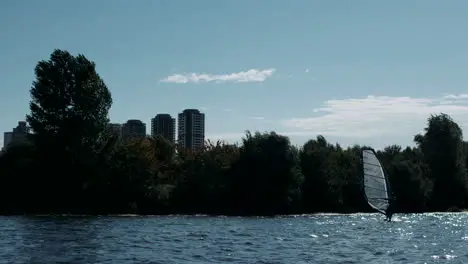 Surfer windsurfing on river in slow motion Water sport at summertime