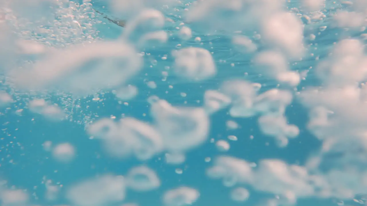 Cinematic underwater slow motion shot of air bubbles in clear blue waters in 4K 120FPS Slomo