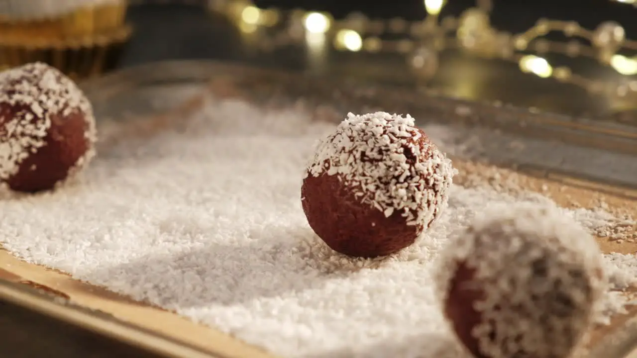 Slowmotion chocolate truffles rolling in coconut flakes