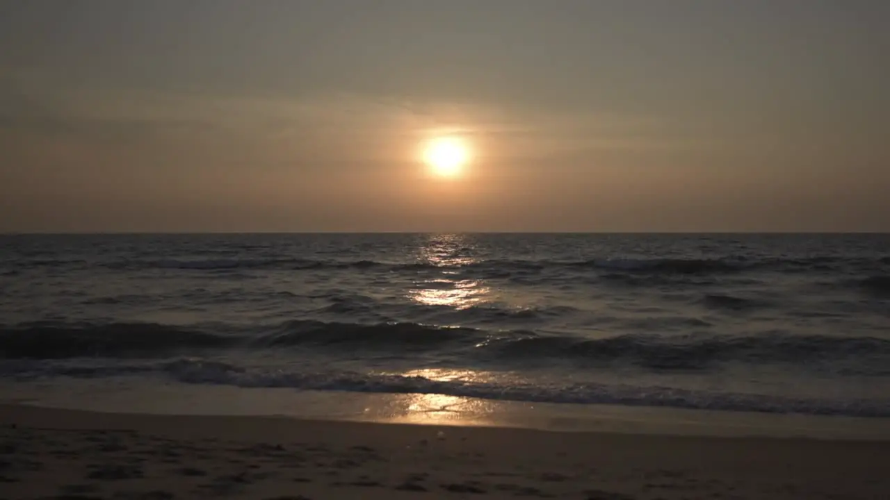 Slow motion waves from the sea with sun in the background