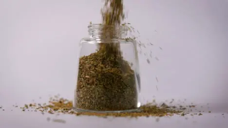 Slow Motion Close Up Oregano Powder Pouring In Jar