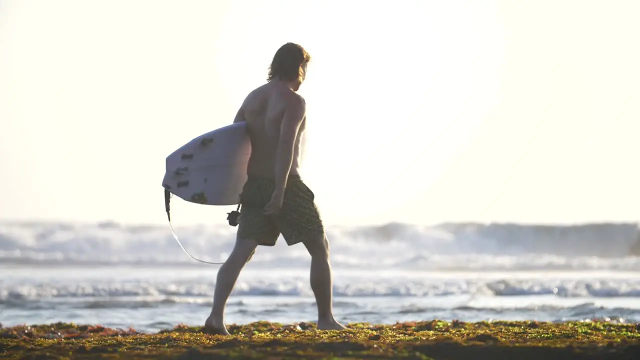 Surfer Walking Along a Beach