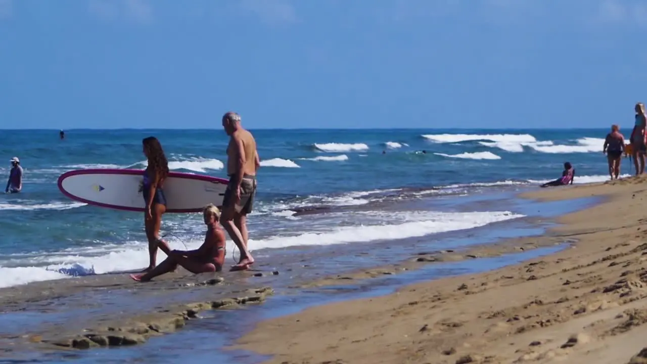 A group of people are walking along the beach