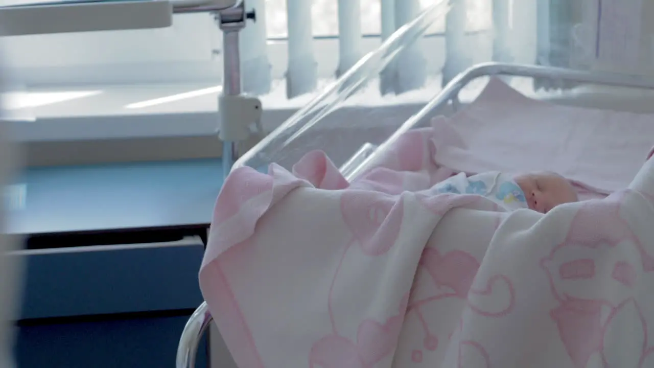 Newborn baby girl sleeping during her first days in maternity hospital