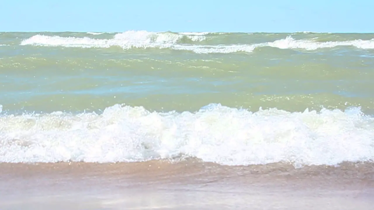 waves crash onto the beach in slo-mo