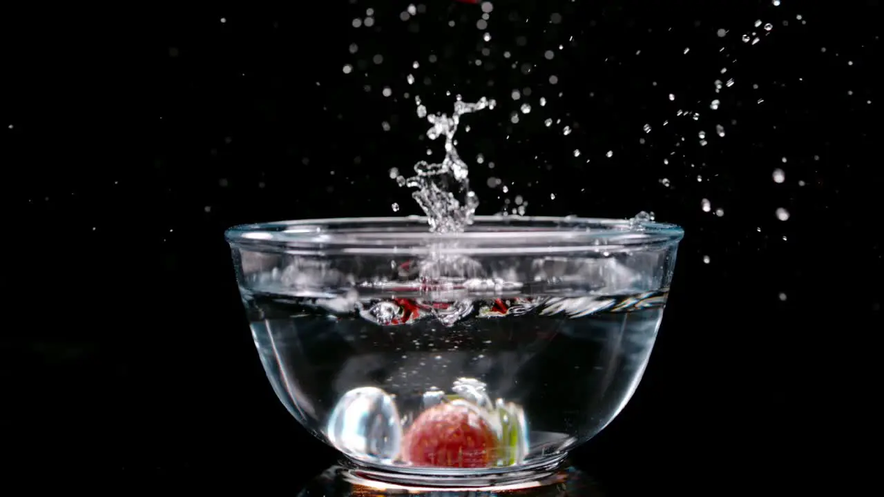 Fresh red strawberry fall into bowl full of water ultra slow motion view