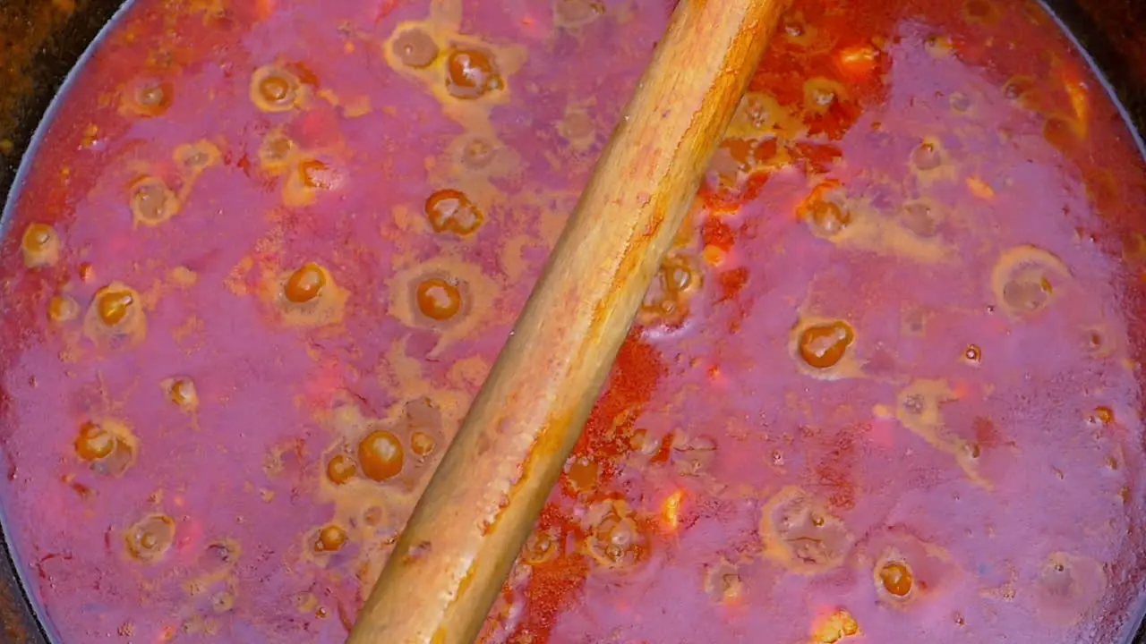 slow motion of traditional Hungarian goulash boiling in a black cauldron