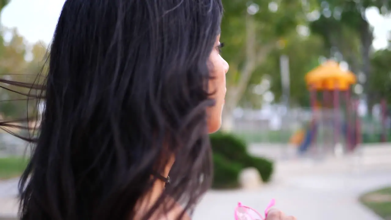 A young hispanic woman hipster wearing vintage fashion clothing in a park playground