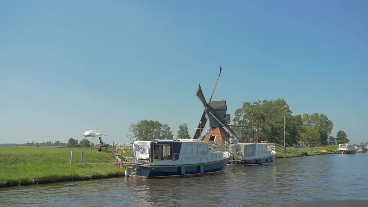 Dutch Old American Windmill near the water sailing past in slowmotion turning in the wind