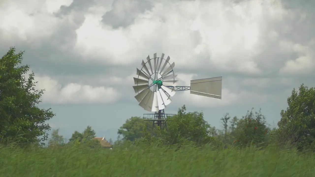 Dutch Old American Windmill near the water ans reed a small Dolly shot in slowmotion turning in the wind