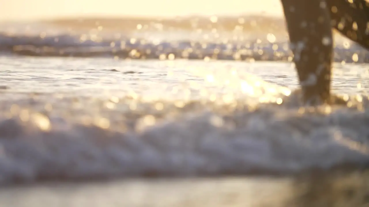 Close-Up of Legs Walking in the Surf