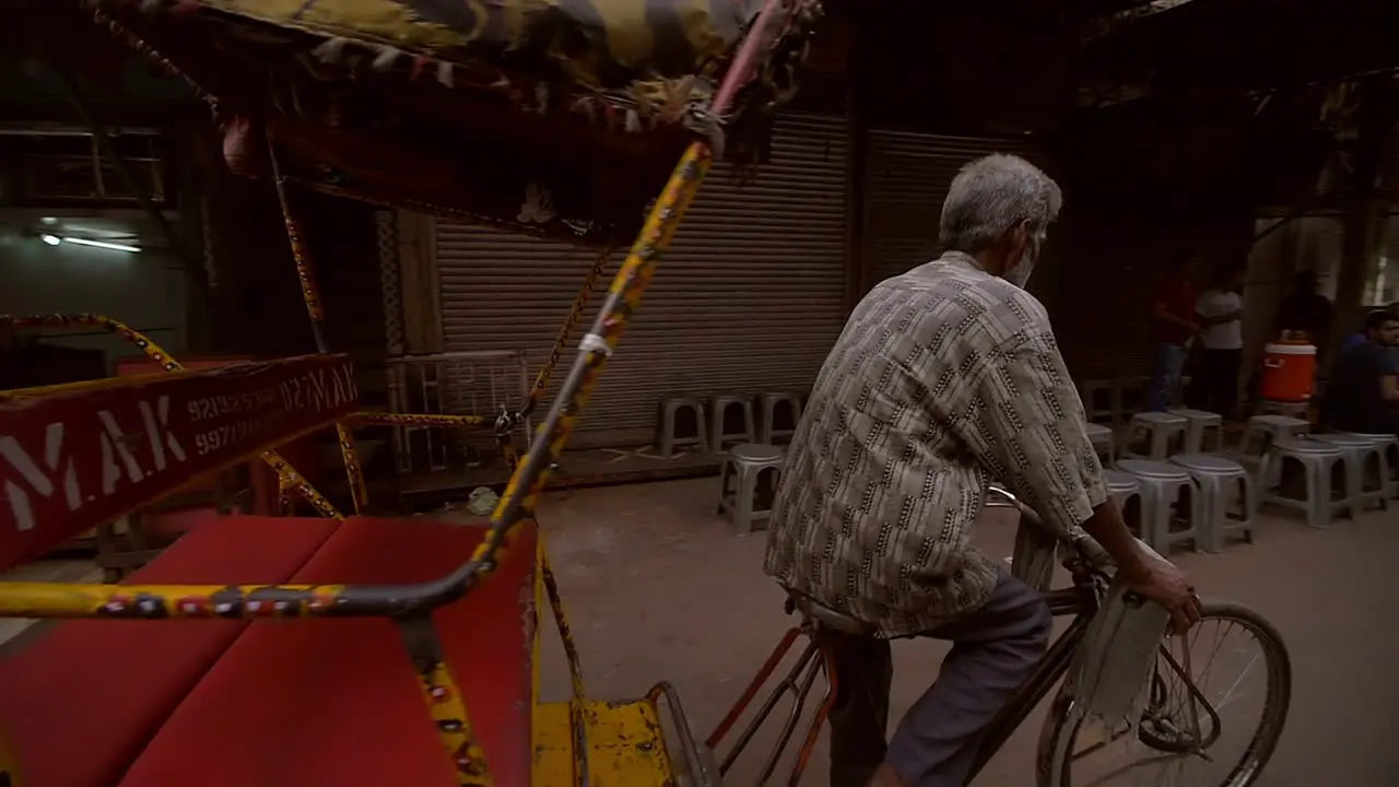 A Man Steers a Rickshaw Down a Delhi Street