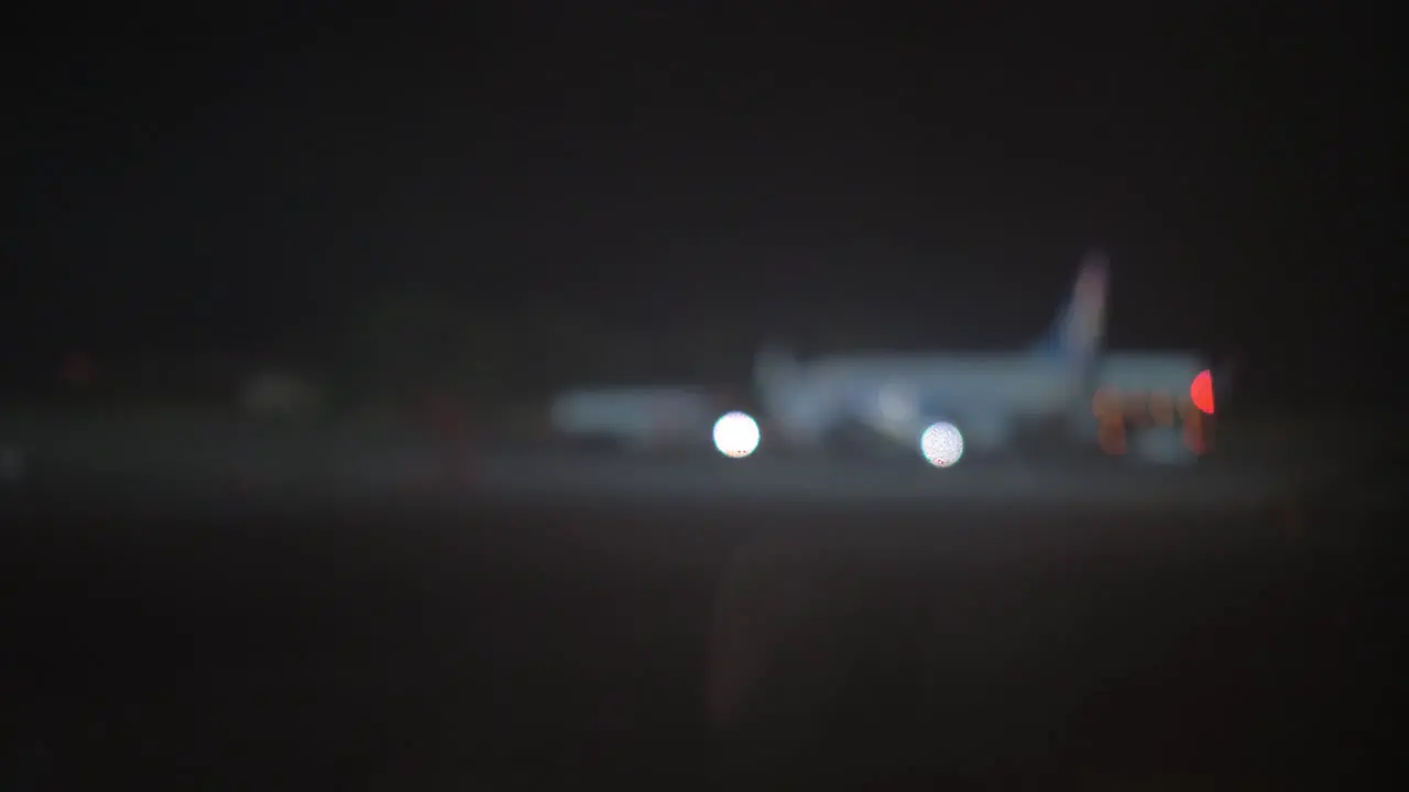 Night view of plane and aircraft tow tractor at the airport defocus