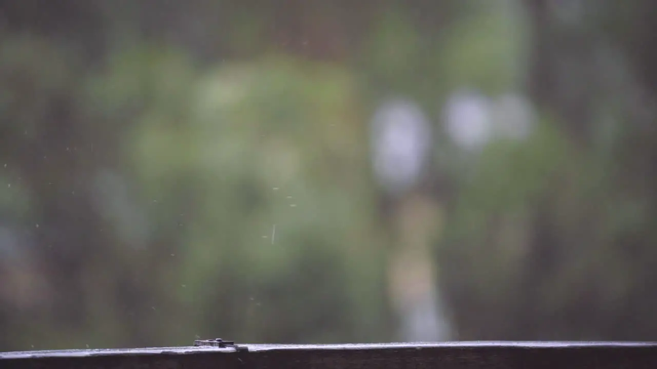 Slow Motion of Raindrops Falling on Wooden Railing