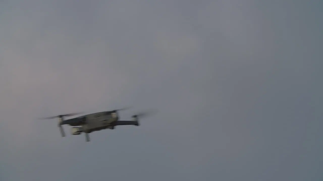 Quadrocopter flying against evening sky