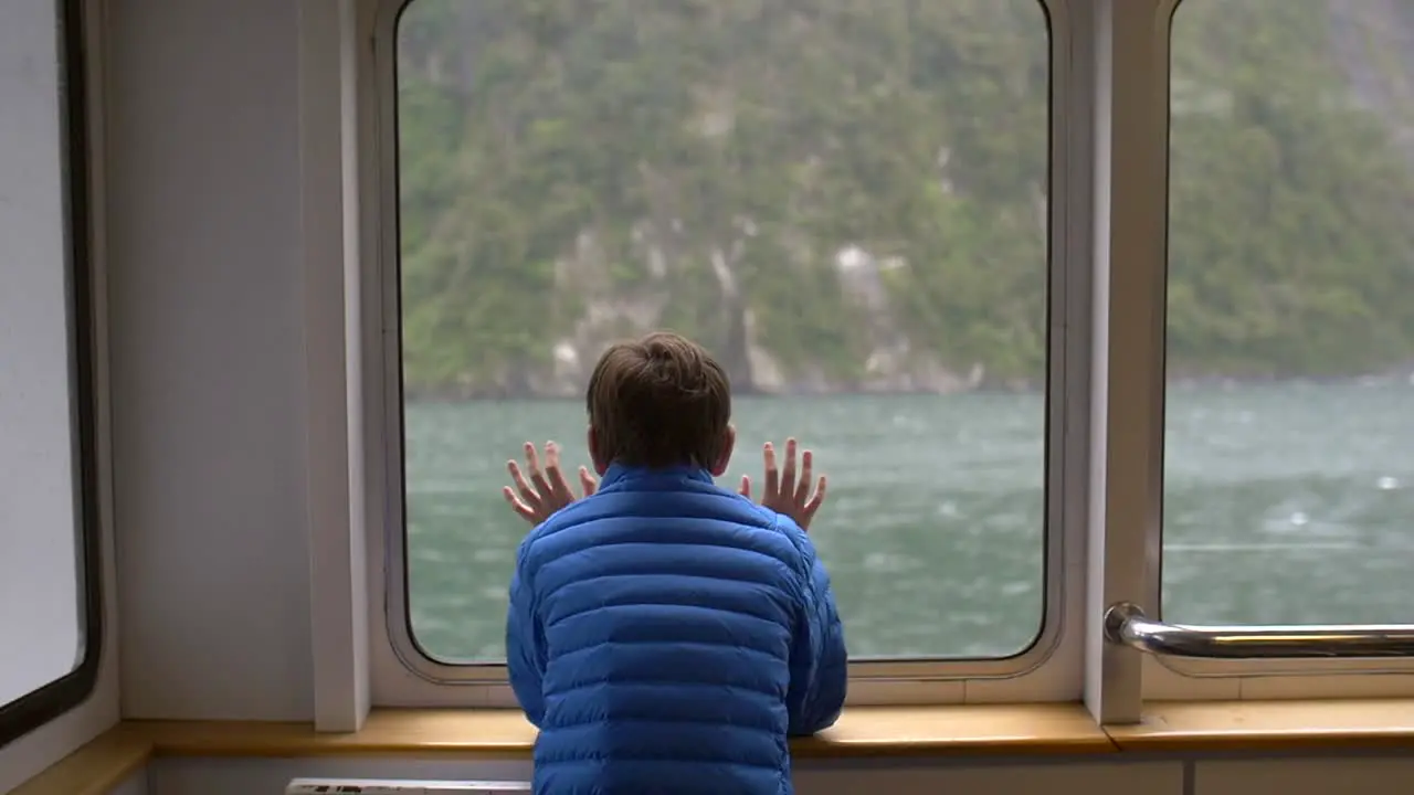 Young Boy Looking Out of a Ship Window 2