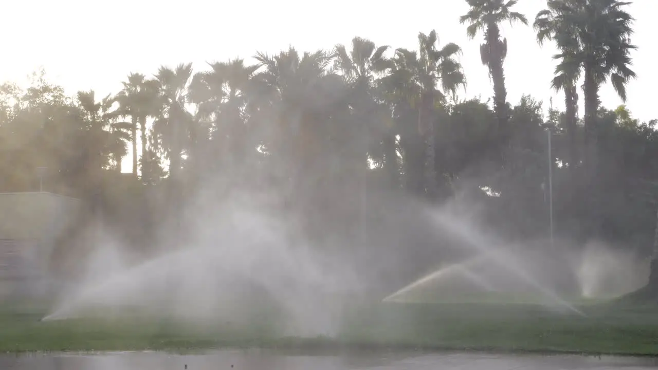 Automatic sprinklers watering lawns in the street