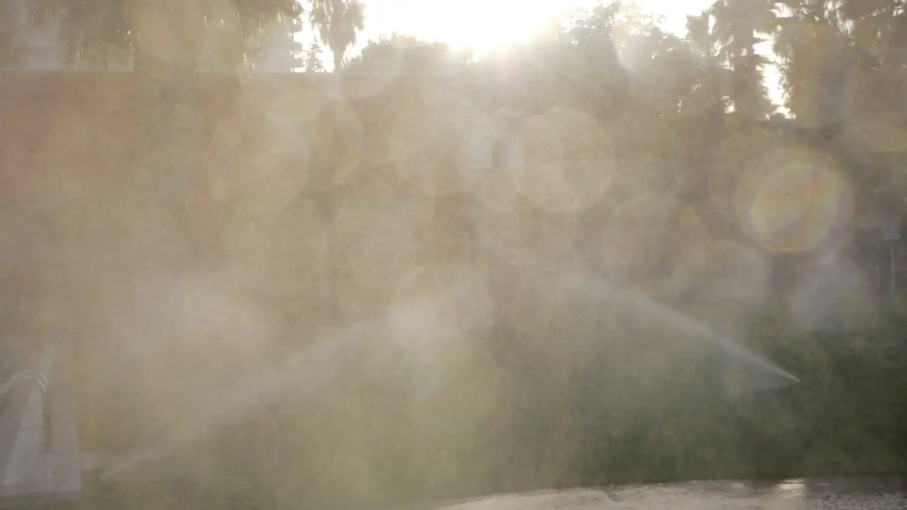 Watering lawns with garden sprinklers view in sun light