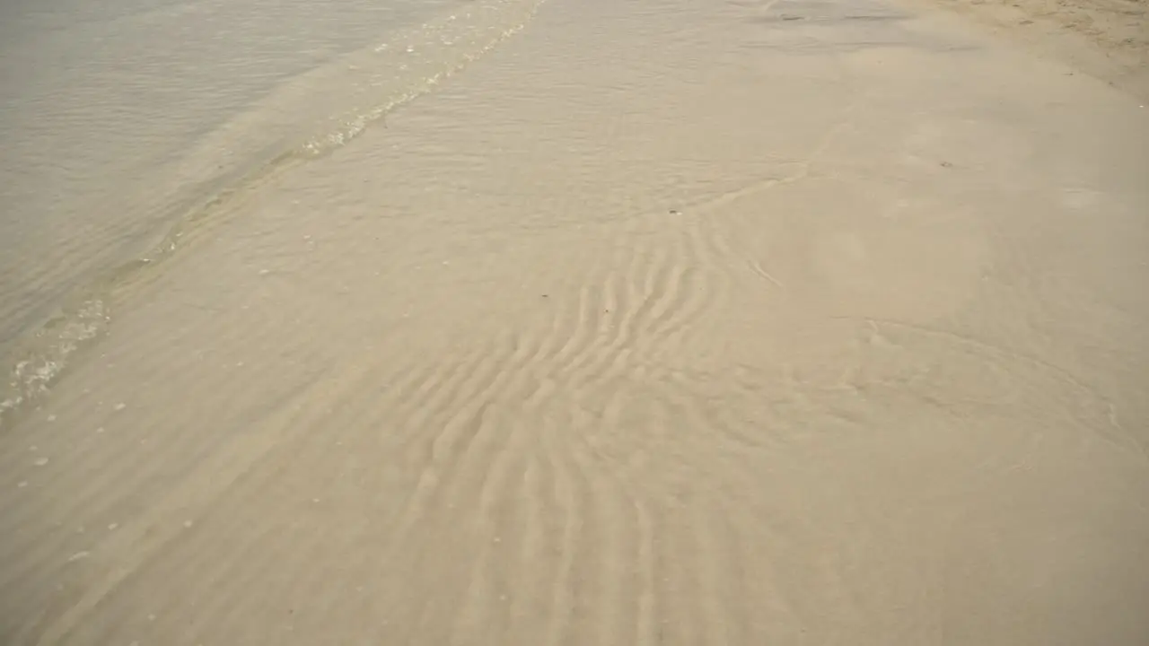 ocean waves calmly glide through the sand 4K UHD