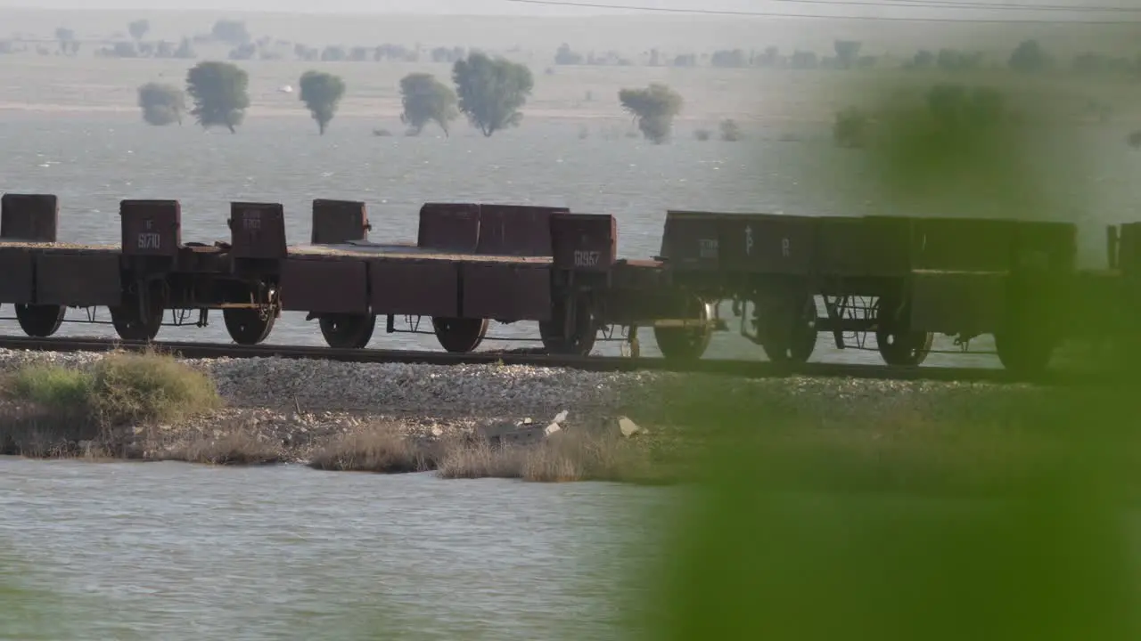 View Of Empty Rail Wagons On Tracks Seen Through Bokeh Green Tree Branches In Sindh Pakistan